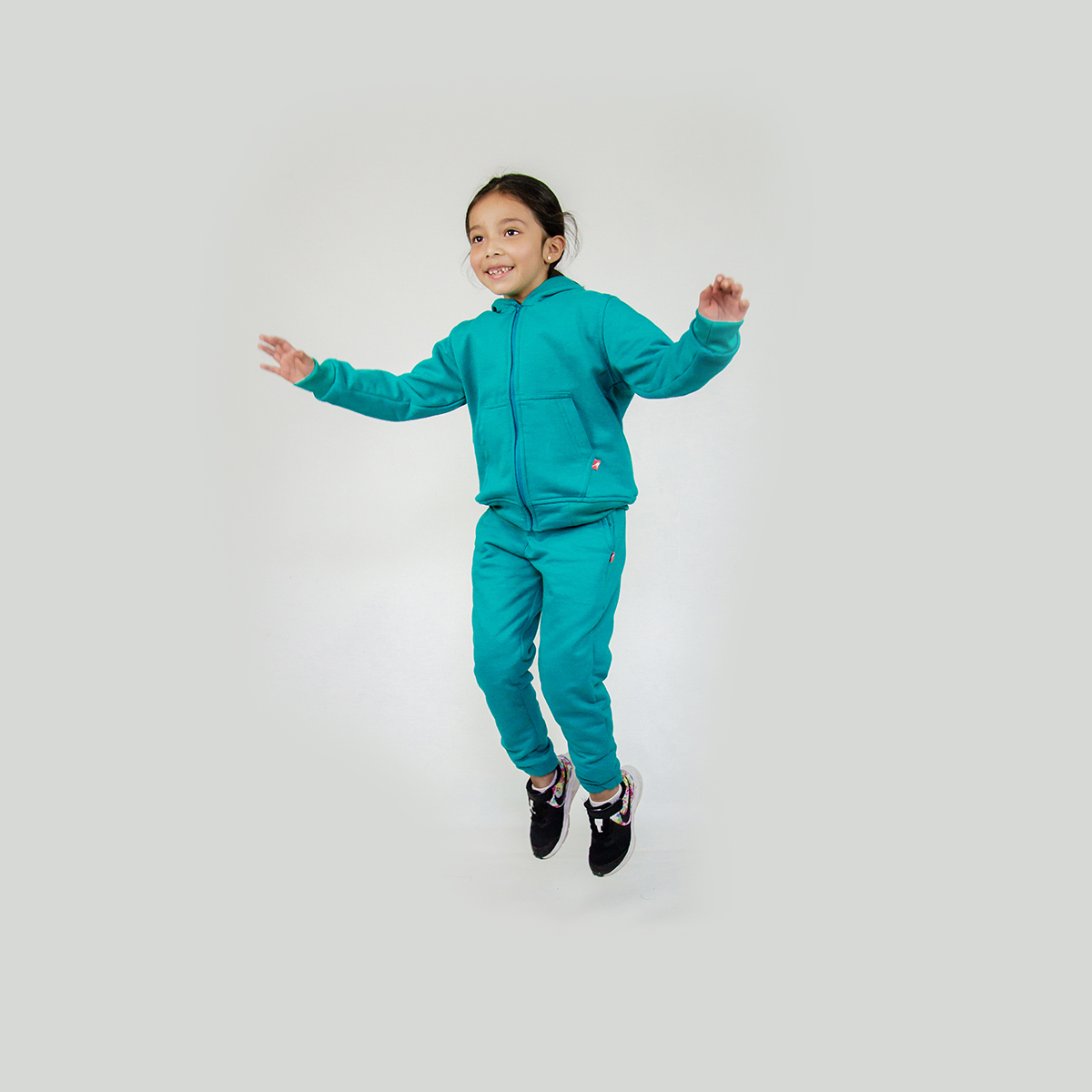 niña vistiendo pants y chumpa de algodon color turquesa